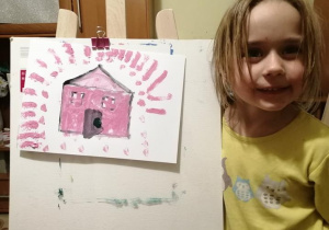 Dziewczynka ze swoim rysunkiem domu
